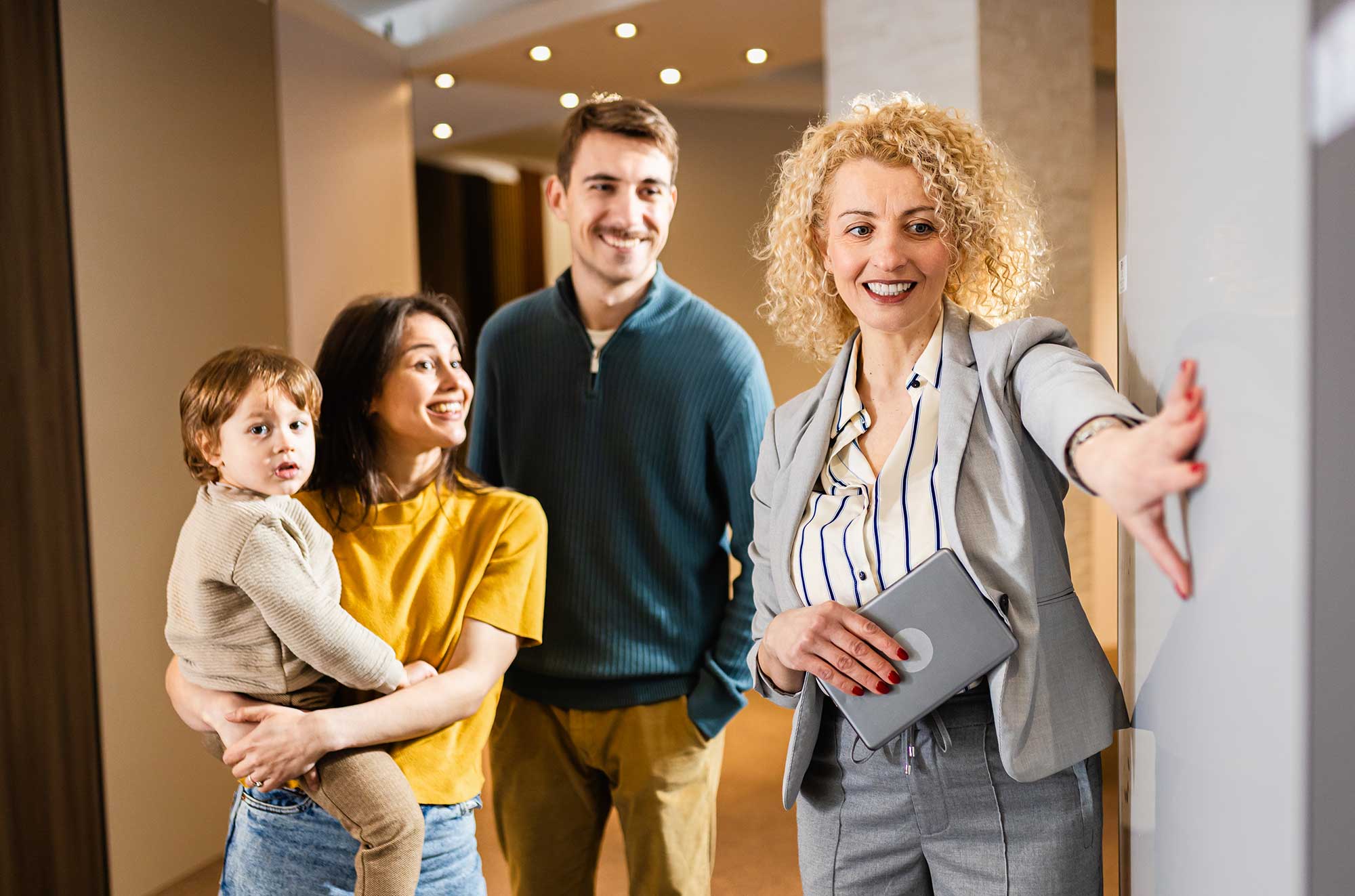saleswoman-showing-a-young-couple-with-a-child